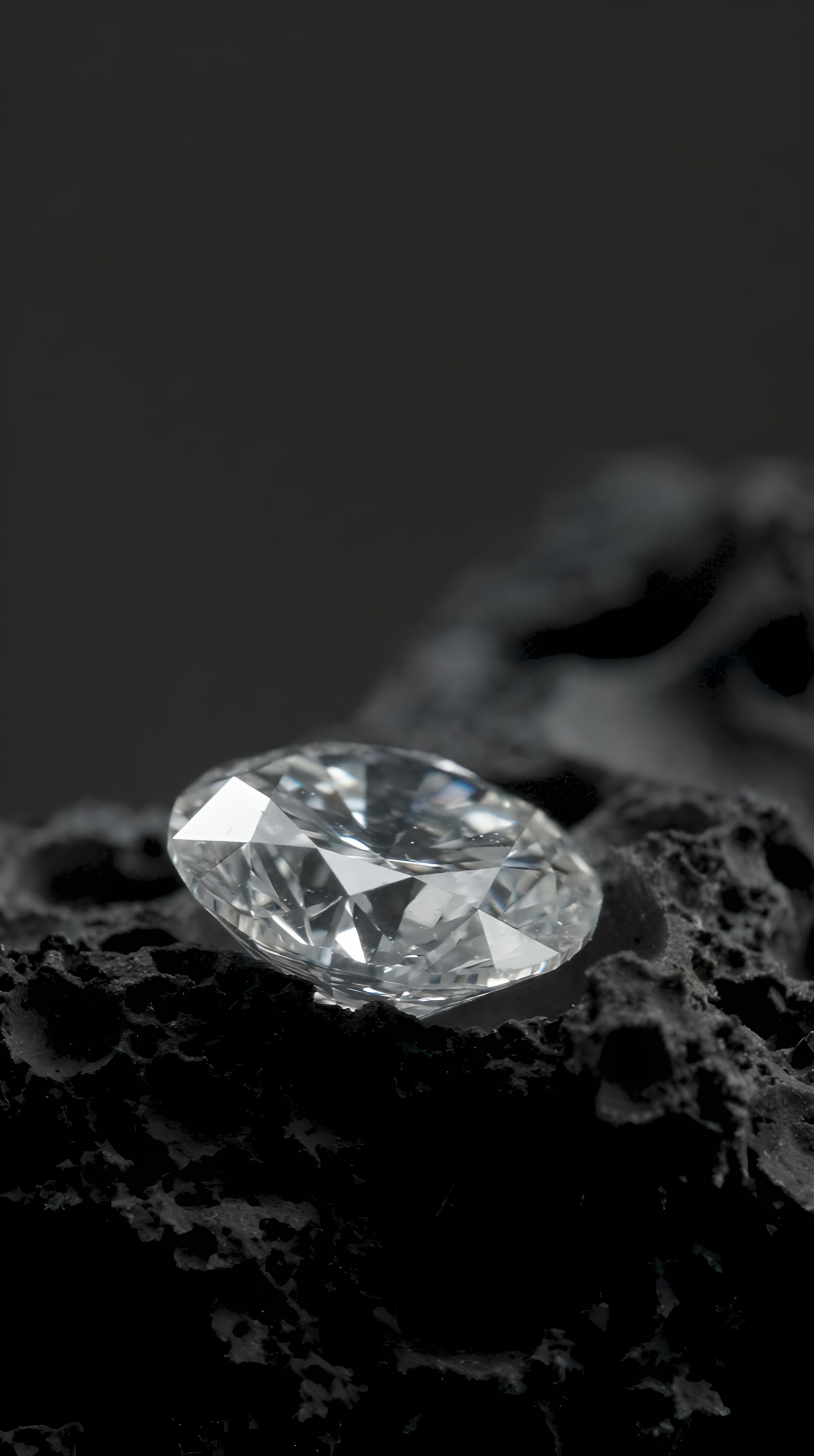 A cut diamond resting on dark Hawaiian volcanic rock