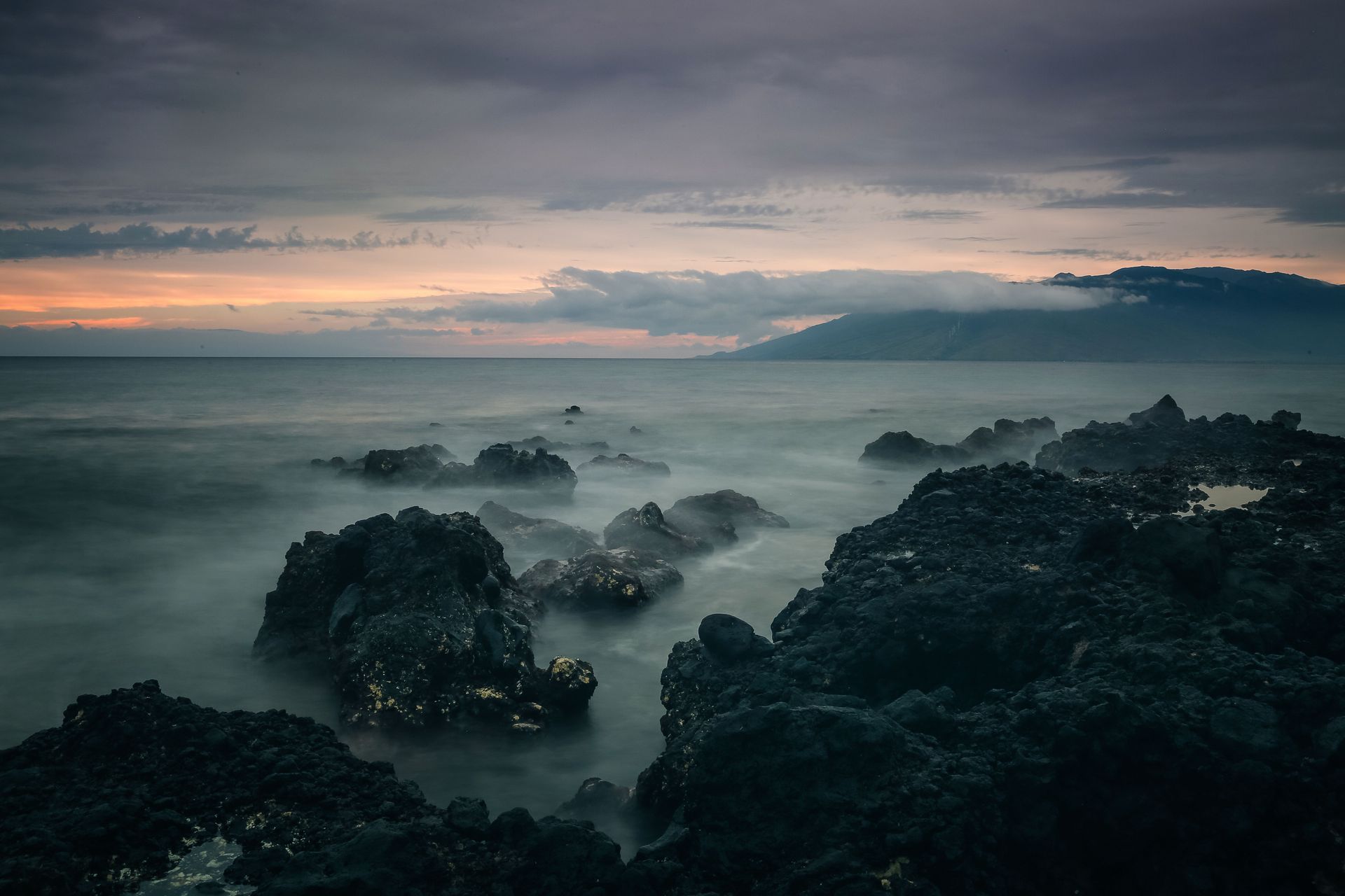 Volcanic coastline and ocean at dusk along the Kona coast of Hawaii's Big Island